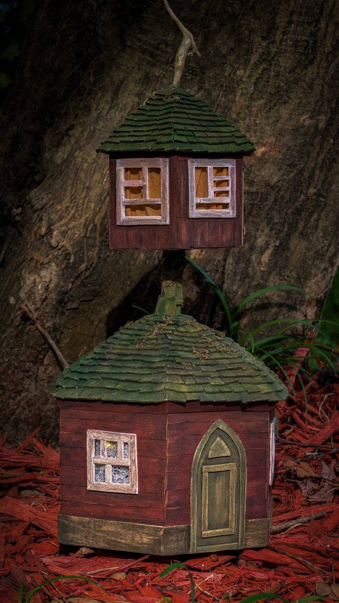 The same tower after dark, every window a warm amber square against the bark