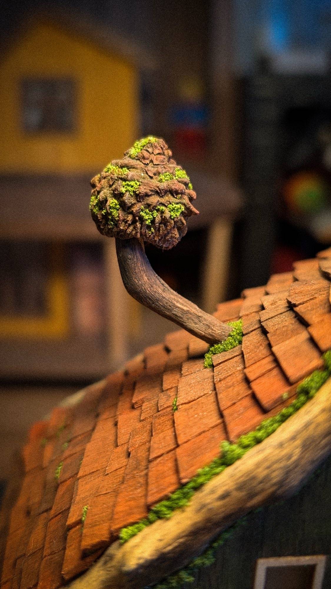 A tiny mushroom on a bent twig stem, glued to the roof ridge
