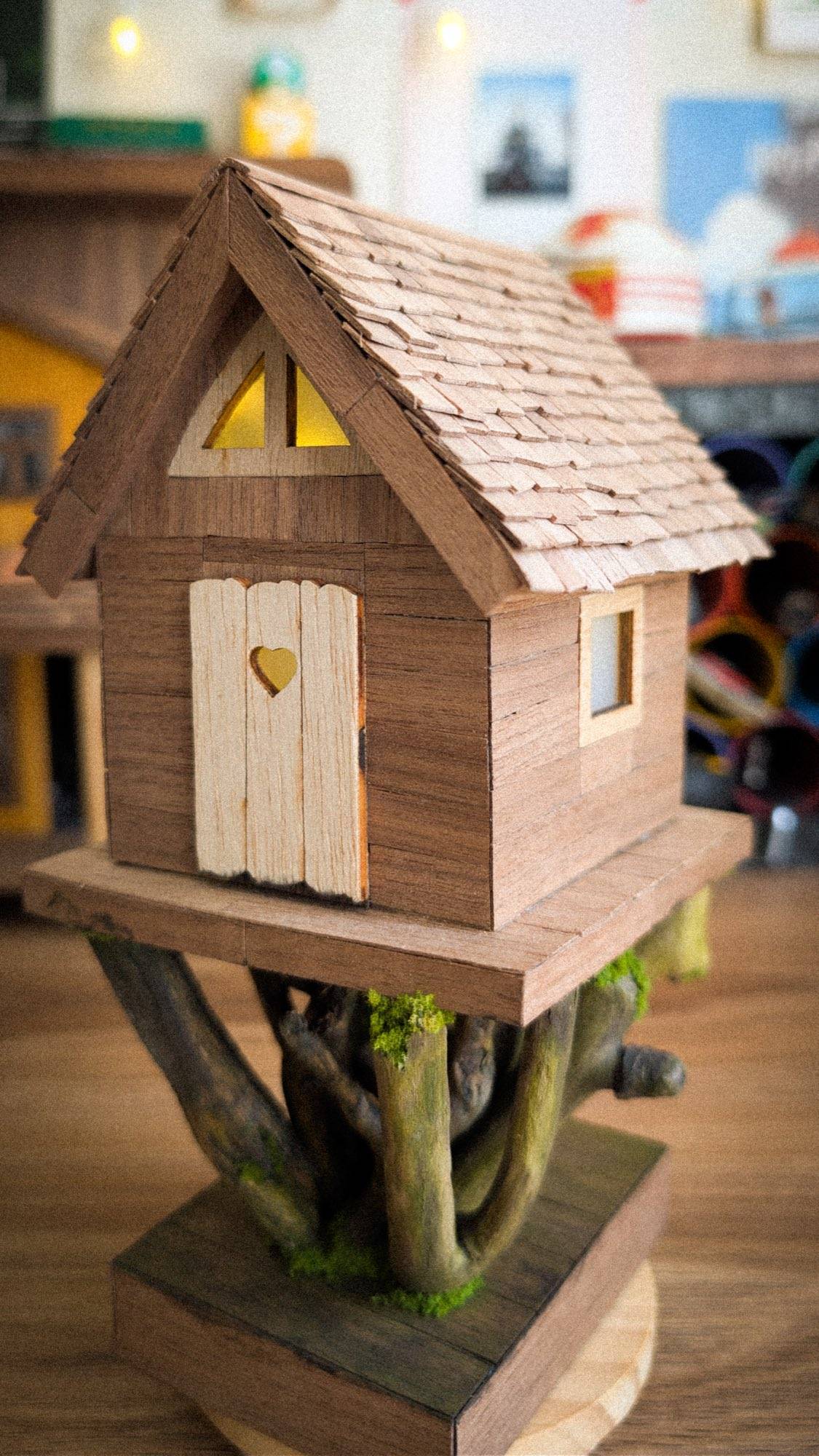 The same cottage before paint, bare wood on its driftwood roots